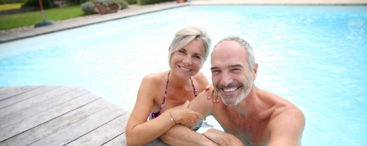 Mann und Frau genießen Rente am Pool